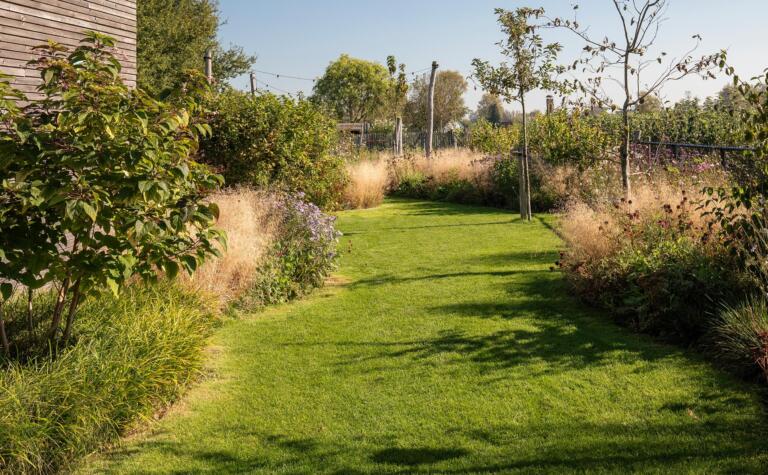 Greenarchitects stefaan willems landschapsarchitect serskamp moderne woning houten palen bloeirijk grasland sfeerlampen 02