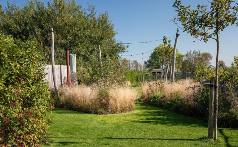 Greenarchitects stefaan willems tuinarchitect serskamp kastanje afsluiting houten palen sfeerlampen buitenkachel bloeirijk grasland aster 02